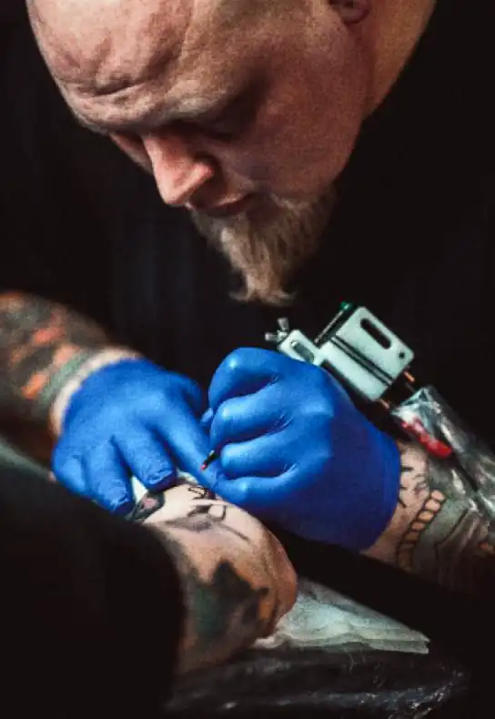 Tattoo artist tattooing arm with award winning tattoo